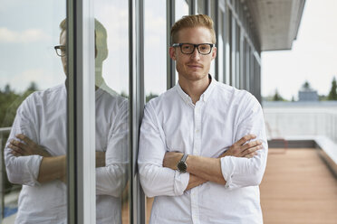 Porträt eines selbstbewussten Geschäftsmannes, der sich an ein Fenster lehnt - RBF06782