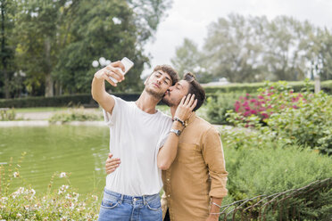 Junges schwules Paar macht Selfie mit Smartphone im Stadtpark - FBAF00055