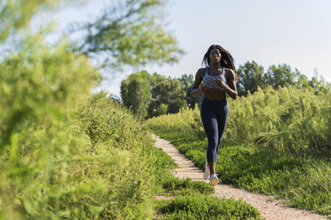 Junger Sportler beim Joggen auf den Feldern - GIOF04441