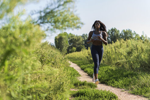 Junger Sportler beim Joggen auf den Feldern - GIOF04441