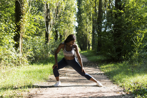 Sportlerin beim Aufwärmen für das Training in der Natur, lizenzfreies Stockfoto