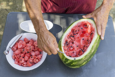 Nahaufnahme eines Mannes, der eine Wassermelone mit einem Schnitzwerkzeug verziert - FBAF00113