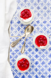 Greek yogurt with red currant sauce on blue patterned tiles - LVF07445