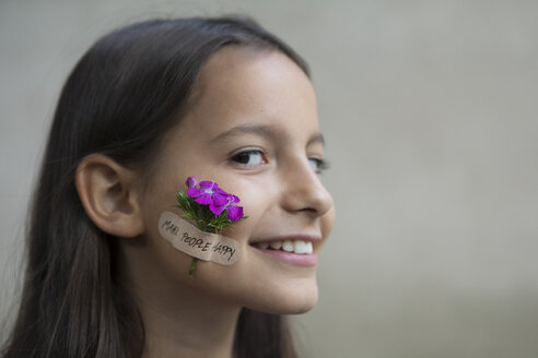 Porträt eines lächelnden Mädchens mit Blumenkopf auf der Wange - PSTF00199