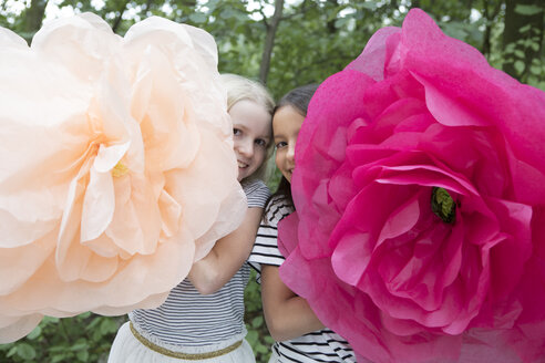 Zwei lächelnde Mädchen mit zwei übergroßen Kunstblumen - PSTF00209