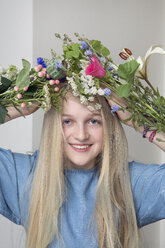 Porträt eines lächelnden blonden Mädchens mit Blumenstrauß - PSTF00216
