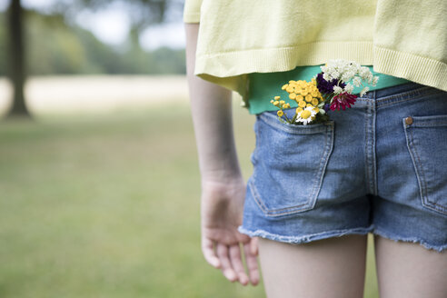 Blumen in der Tasche der Jeans-Shorts eines Mädchens - PSTF00255