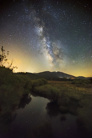 The Milky way shines in the night sky over Truckee's Martis Valley and Northstar's Mt. pluto stock photo