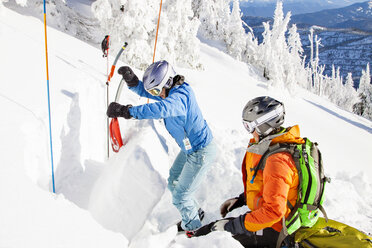 Zwei Skifahrerinnen graben eine verlängerte Testschneegrube, um die Lawinengefahr zu beurteilen - AURF05676