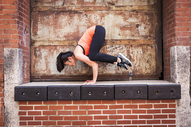 Woman Doing Exercise On Top Of Brick Wall - AURF05743