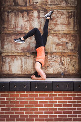 Woman Doing Exercise On Top Of Brick Wall - AURF05744