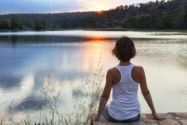 Frau beim Yoga bei Sonnenuntergang im Stausee von Valbona, J├║car.Teruel Hydrographic Confederation, Spanien - AURF05763