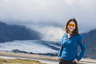 Frau lächelnd vor einem Gletscher - AURF05779