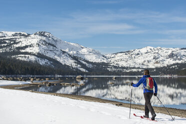 Woman skiing along shores of Donner Lake - AURF05799