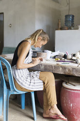 Junge Frau in der Keramikwerkstatt. - AURF05830