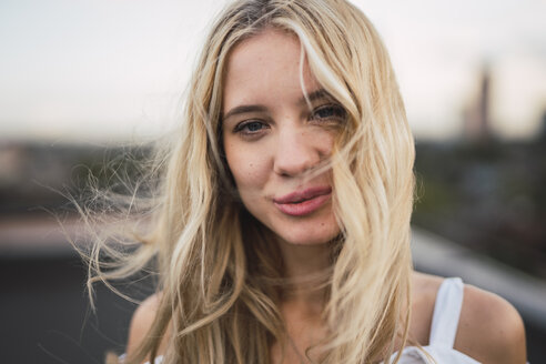 Portrait of smiling blond young woman outdoors - KKAF02007