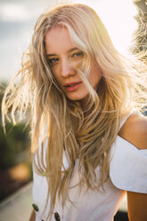 Portrait of blond young woman wearing white dress outdoors - KKAF02009