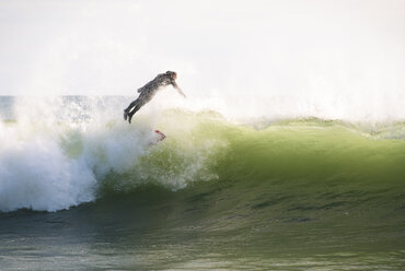 Ein Surfer, der an einem sonnigen Wintertag in Rhode Island von einer Welle abspringt - AURF05866