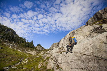 Ein Wanderer ruht sich auf einem Felsvorsprung aus, Garibaldi Provincial Park - AURF05895