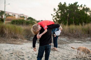 Ein Mann trägt seinen Sohn über der Schulter in einem Sumpfgebiet in Wrightsville Beach, NC. - AURF05910