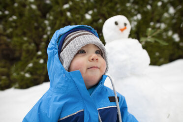 Kleiner Junge und Schneemann im Hintergrund, Langley, British Columbia, Kanada - AURF05963