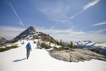 Backpacker approaching Needle Peak in winter, Hope, British Columbia, Canada - AURF05965