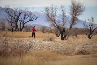 Adult woman running in savannah valley of Sierra Nevada Mountains - AURF05987