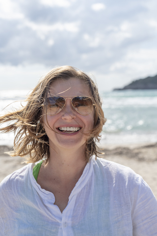 Porträt einer glücklichen Frau am Strand, lizenzfreies Stockfoto