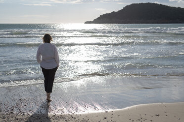 Griechenland, Parga, Frau an der Strandpromenade im Gegenlicht stehend - PSIF00077