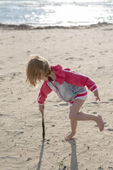 Greece, Parga, little girl playing with a stick on the beach - PSIF00079