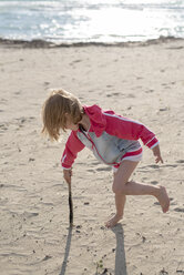 Griechenland, Parga, kleines Mädchen spielt mit einem Stock am Strand - PSIF00079
