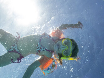 Kleines Mädchen mit Taucherbrille schwimmt im Wasser - PSIF00091