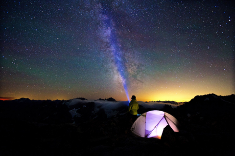 Camper lenkt Taschenlampe entlang der Milchstraße, lizenzfreies Stockfoto