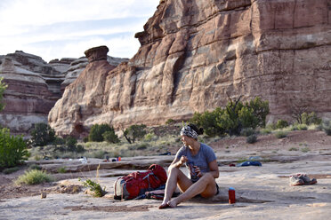 Wanderin beim Essen nach einer Wanderung im Canyonlands National Park, Moab, Utah, USA - AURF06059