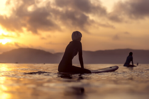 Weibliche Surferin im Meer bei Sonnenuntergang - AURF06075