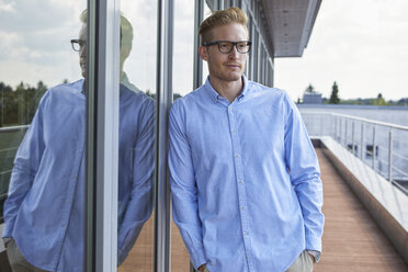 Portrait of confident young man standing on balcony - RBF06797