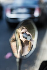 Young woman drinking coffee to go, mirror image - GIOF04497