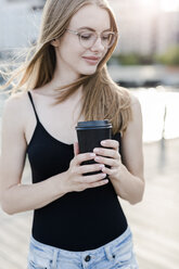 Junge Frau hält eine Tasse Kaffee - GIOF04512