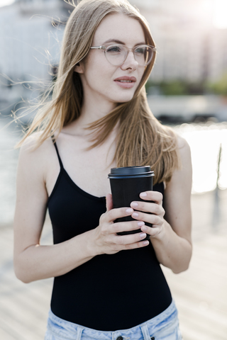 Junge Frau hält eine Tasse Kaffee, lizenzfreies Stockfoto