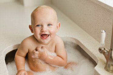 Porträt eines lachenden kleinen Jungen, der beim Baden im Waschbecken Spaß hat - NMS00273