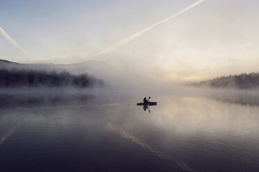 Young woman enjoys early morning paddle in kayak through mist on Daicey Pond in Maine's Baxter State Park, USA - AURF06114