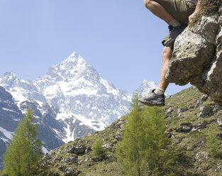 Detail of feet hanging over butress in mountains - AURF06139