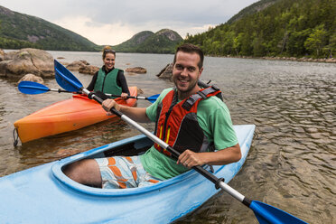 Paar lächelt in die Kamera beim Kajakfahren auf dem Jordan Pond im Acadia National Park, Maine, USA - AURF06169