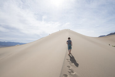 Clouds over boy walking on Mesquite Flat Sand Dunes in Death Valley National Park, California, USA - AURF06186