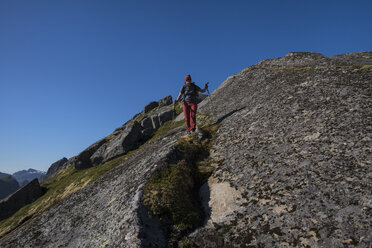 Wanderin klettert den felsigen Berg hinunter zum Nonstind-Gipfel - AURF06217