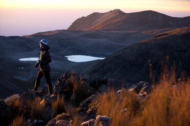 Fotografin steht bei Sonnenaufgang auf einem Felsen in den Bergen, Toluca, Mexiko - AURF06258