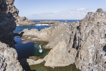 Weibliche Stand Up Paddlerin vergnügt sich im Naturschwimmbad, Teneriffa, Kanarische Inseln, Spanien - AURF06274