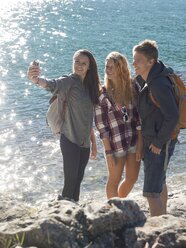 Group of teen hikers take pic with smartphone, mountain lake - AURF06286