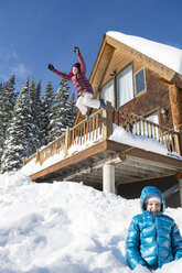 Front view of two young girls jumping into soft snow near Molas Pass, Silverton, Colorado, USA - AURF06301
