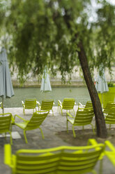 Garden chairs aligned along canal on sunny day - AURF06316